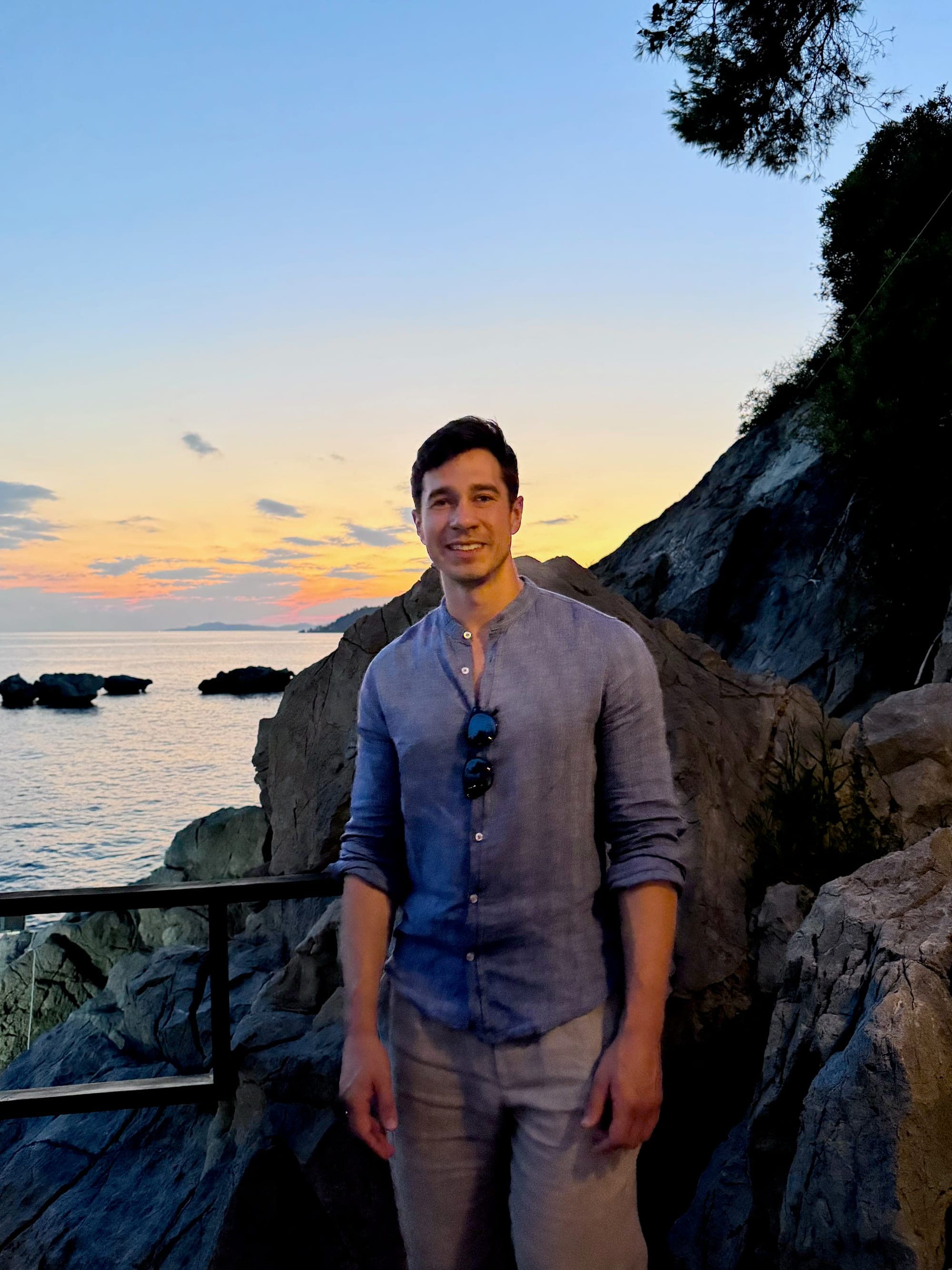 Alex Kanov standing by the sea at sunset